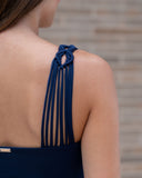 Close-up of handcrafted macramé straps on navy one-piece swimsuit
