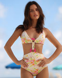 Model wearing the Gioia di Sole one piece swimsuit in an ivory floral print with pink ring details, front view.