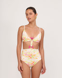 Woman wearing a colorful floral bikini set on a plain background