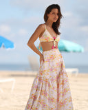 Model wearing Gioia di Sole floral resort pants with wide-leg silhouette and high waist on a beach setting.